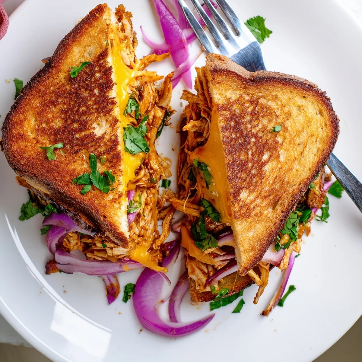 Golden BBQ chicken grilled cheese sandwich with melted cheddar and mozzarella on crispy sourdough bread