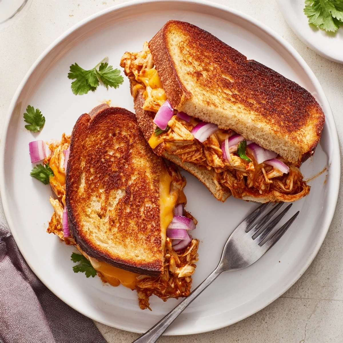 Sliced BBQ chicken grilled cheese featuring tender meat, gooey cheese blend, and buttery toasted crust