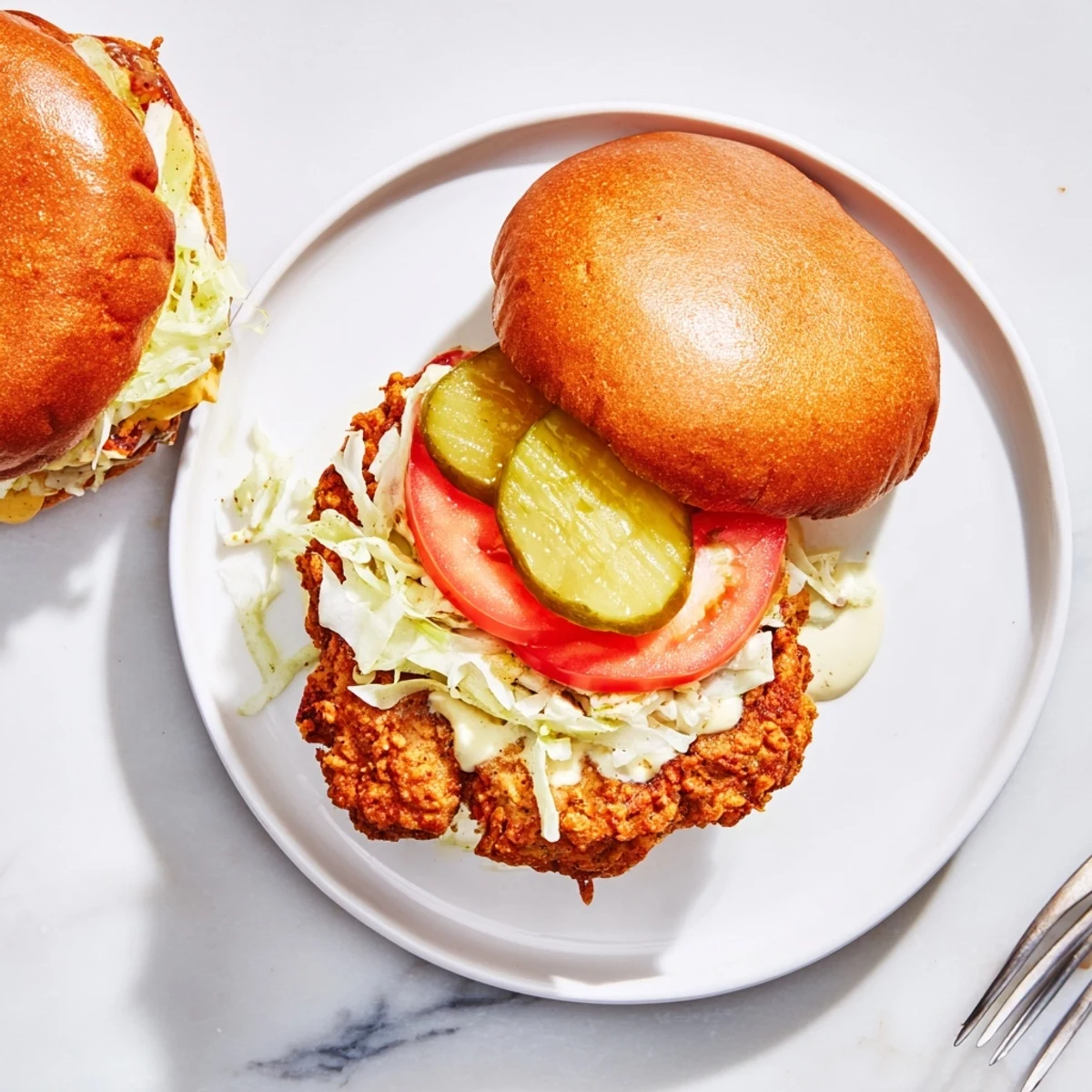 Juicy crispy chicken burger featuring crunchy fried breast and creamy sauce on a warm sesame bun