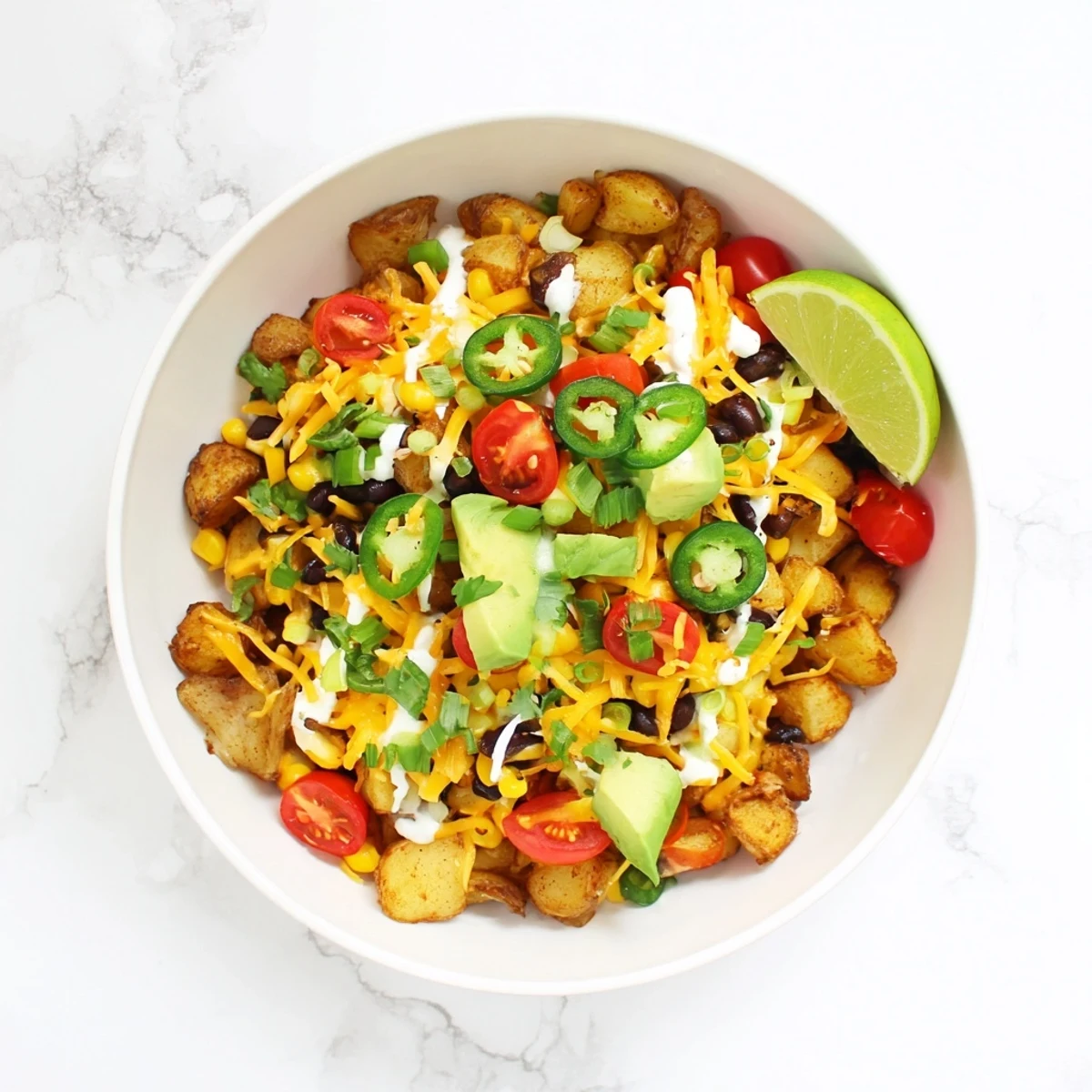 Delicious Loaded Fiesta Potato Bowls featuring zesty potatoes, corn, tomatoes, and cilantro in a hearty dinner bowl.