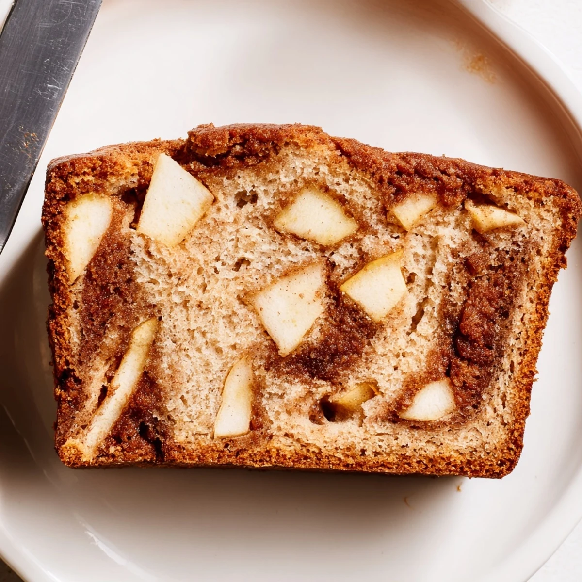 Sliced homemade cinnamon apple bread showing moist interior texture with tender baked apple pieces
