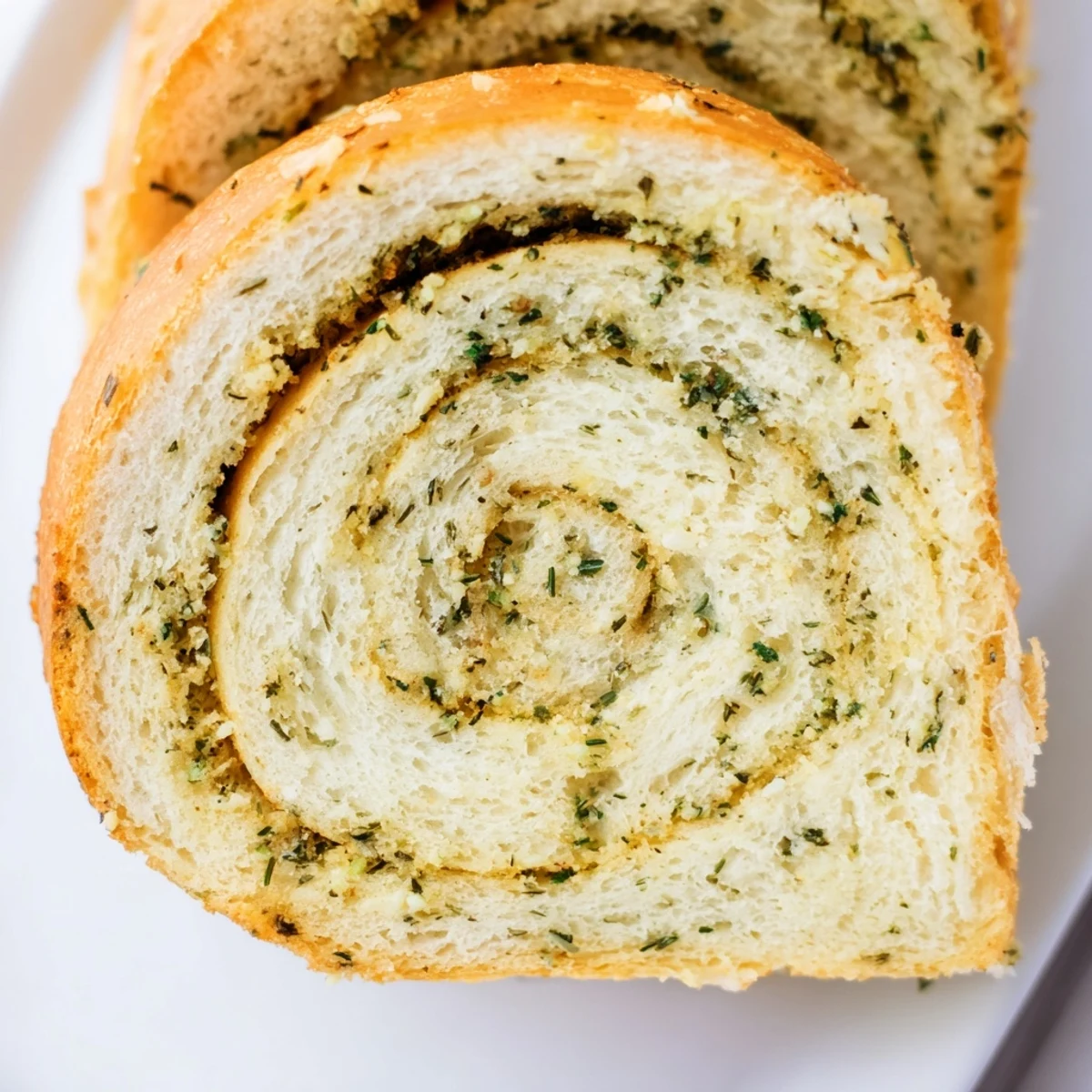 Freshly baked garlic and herb bread showing golden crust and aromatic rosemary garnish