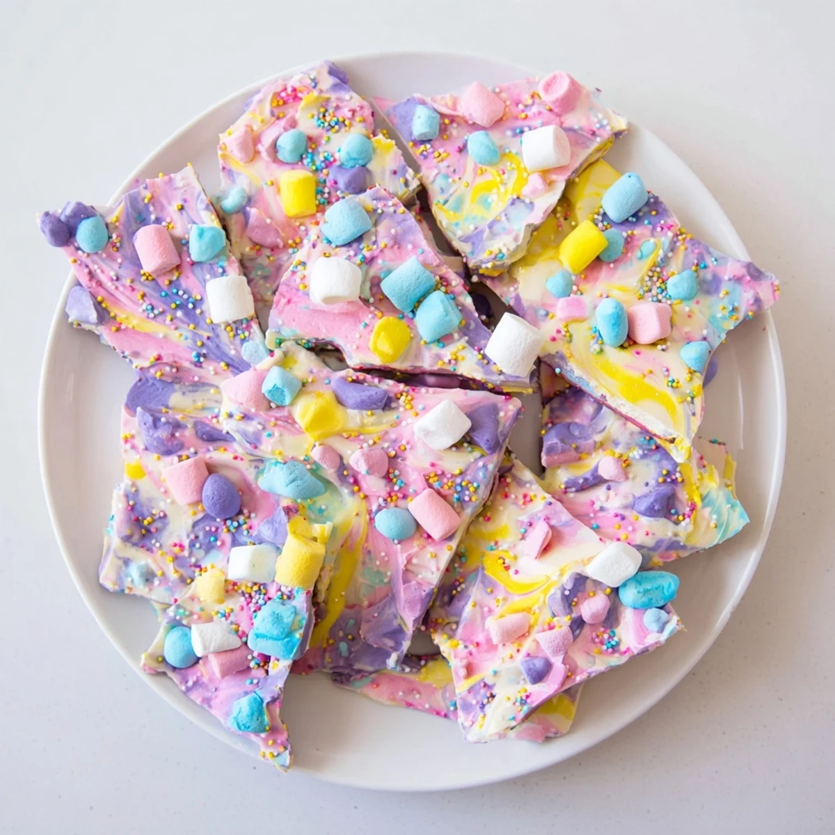 Creamy Easter Marshmallow Bark topped with pastel candy eggs and colorful sprinkles on white chocolate