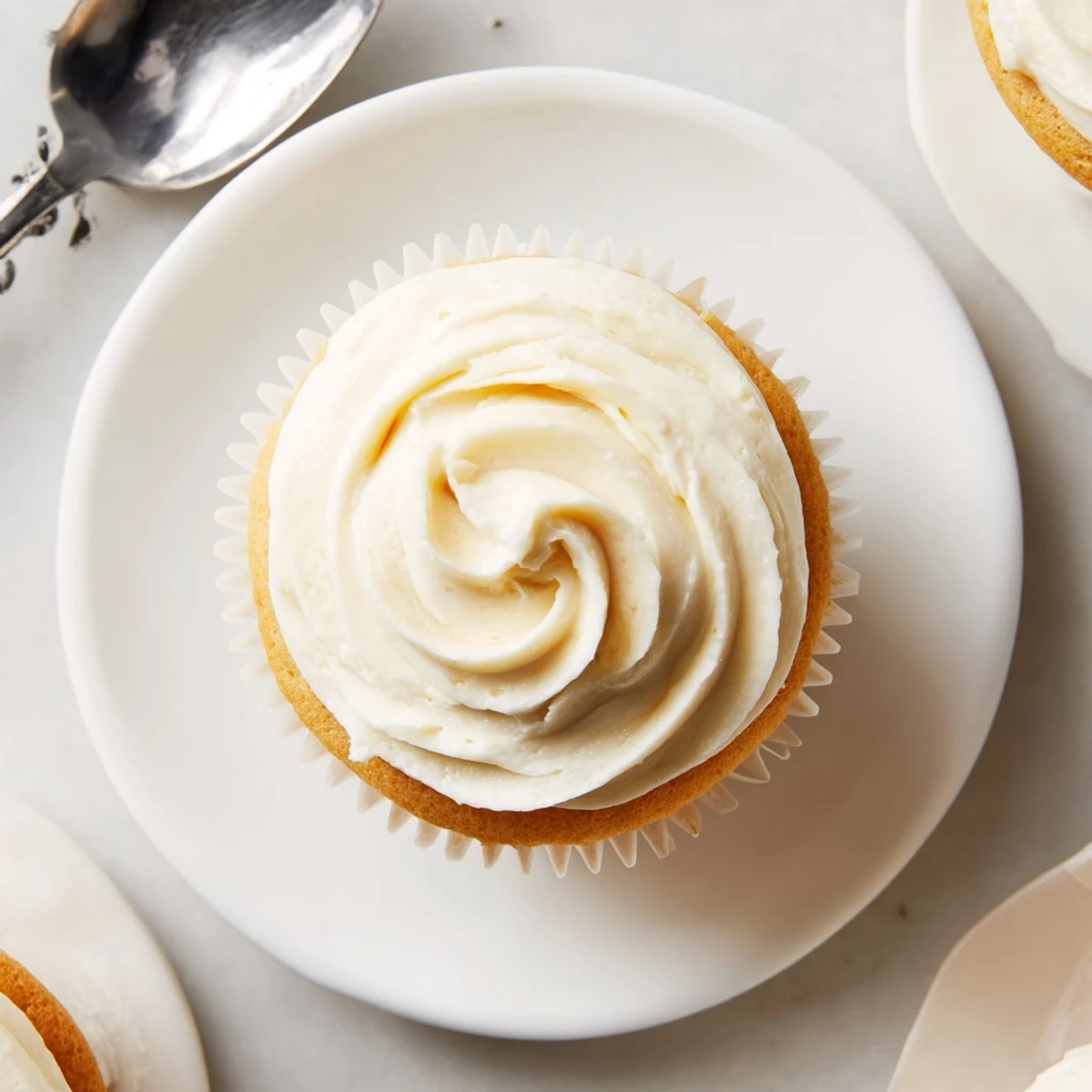 Classic American vanilla cupcakes with swirled vanilla frosting and colorful rainbow sprinkles