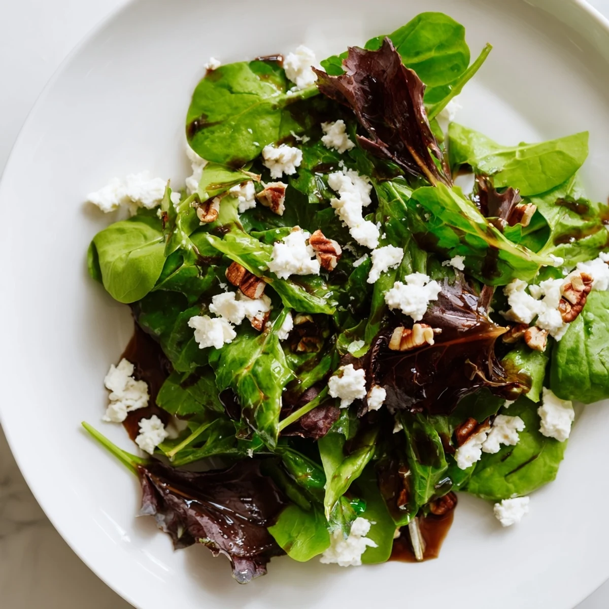 A vibrant spring mix salad with cherry tomatoes, cucumber, and tangy balsamic dressing.