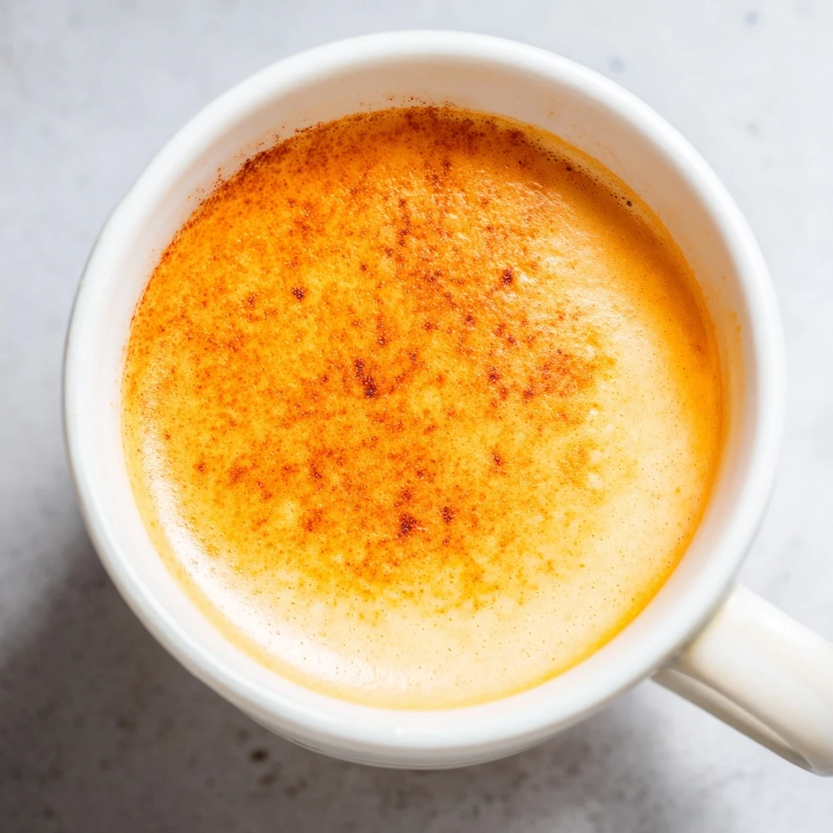 Smooth Korean sweet potato latte poured into a ceramic cup with cinnamon garnish