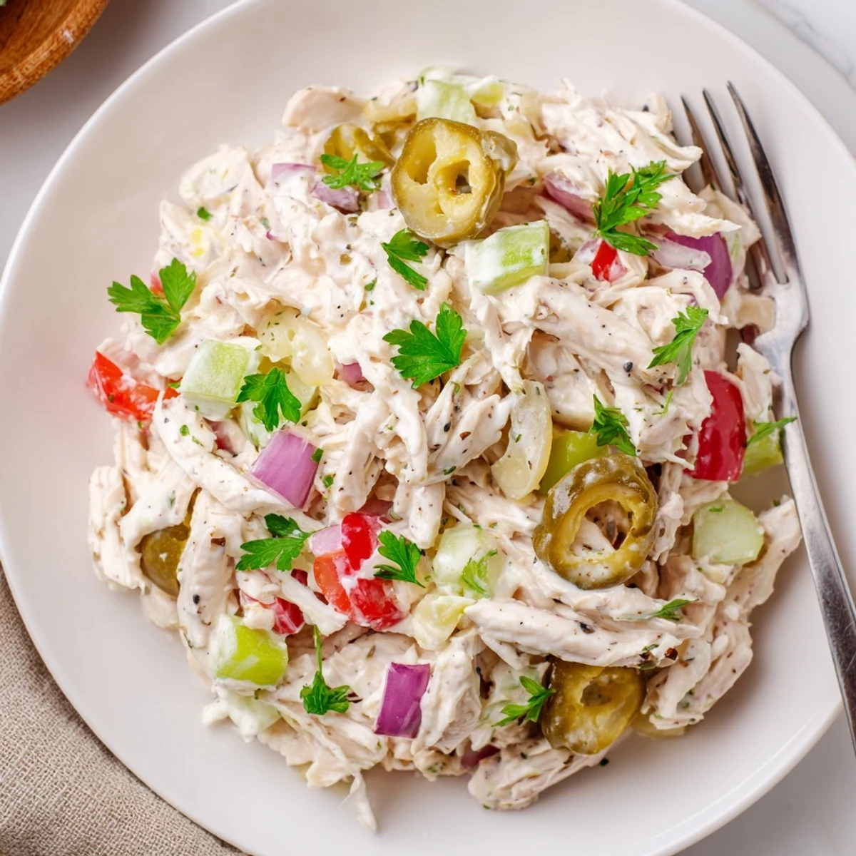 Bowl of High Protein Pepperoncini Chicken Salad chilled, creamy dressing, bright red peppers