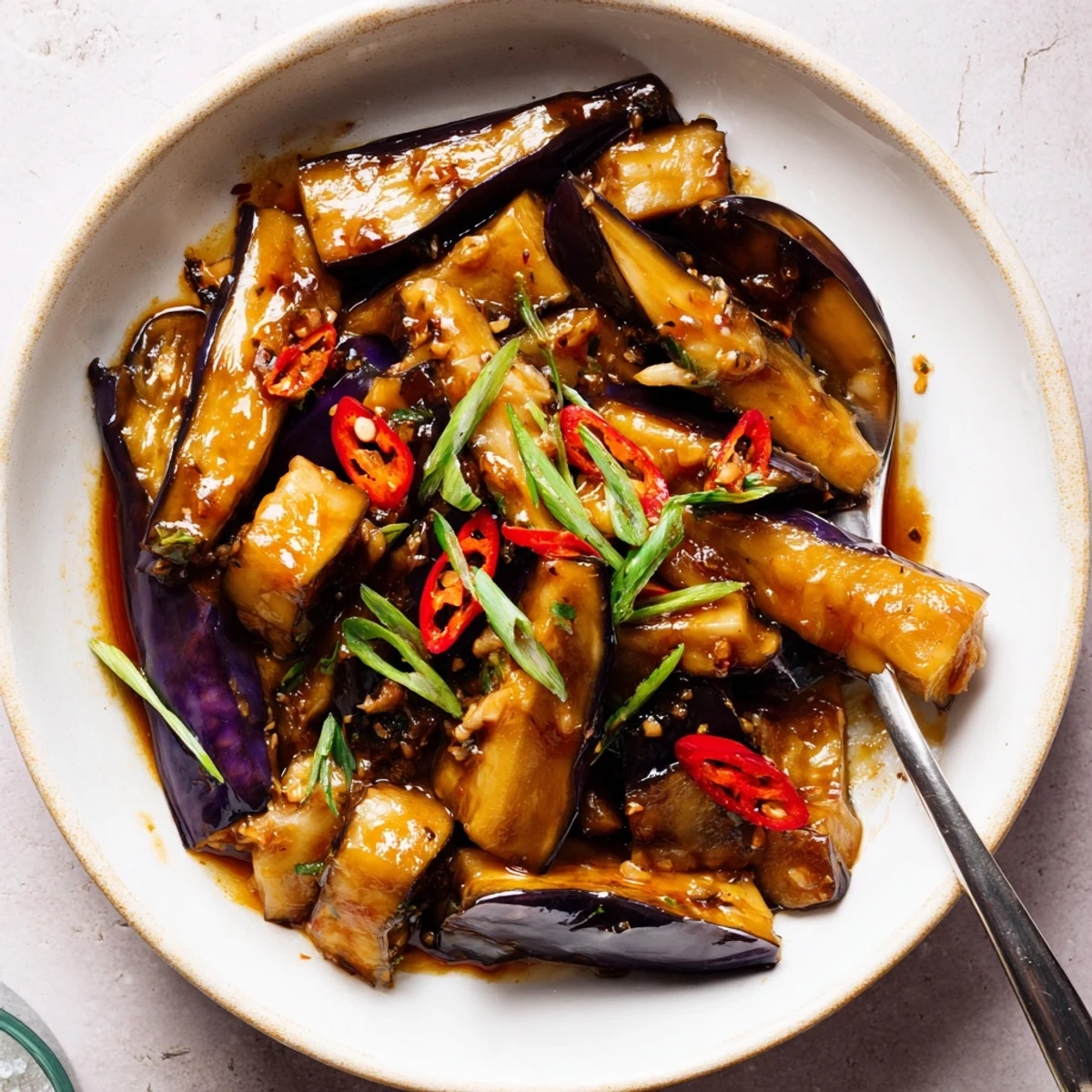 Sichuan Style Braised Aubergines glistening in spicy red sauce over rice.