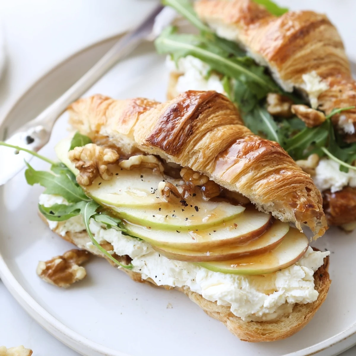 Assembled Apple Goat Cheese Croissant Sandwich ready for light lunch, arugula peeking