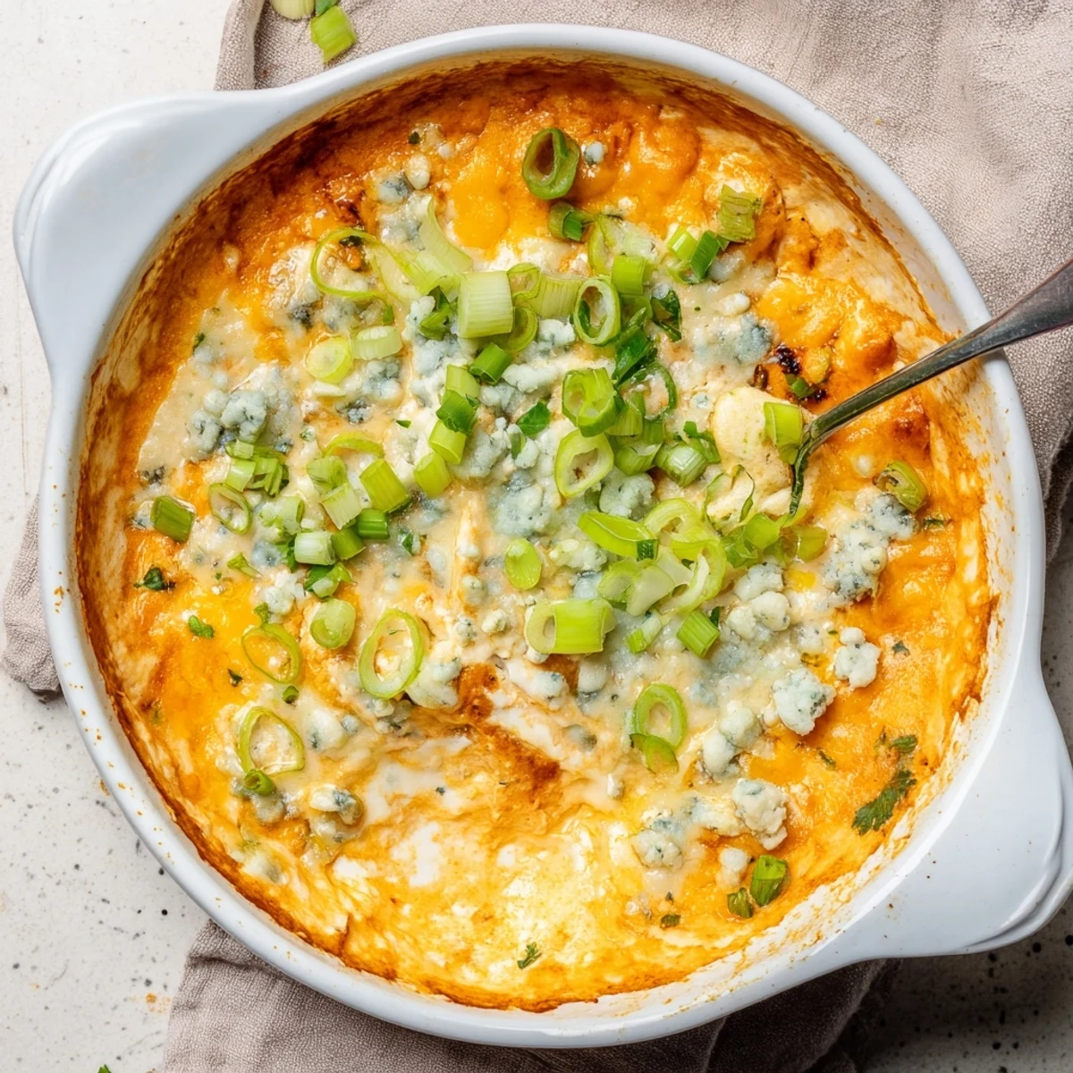 Creamy white bean buffalo dip served warm with tortilla chips and green onion garnish