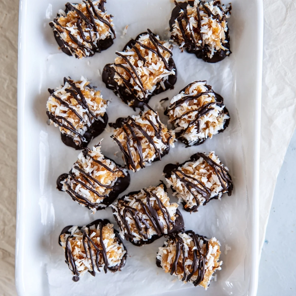 Close-up of layered no bake Samoa bites featuring sticky caramel and chocolate coating
