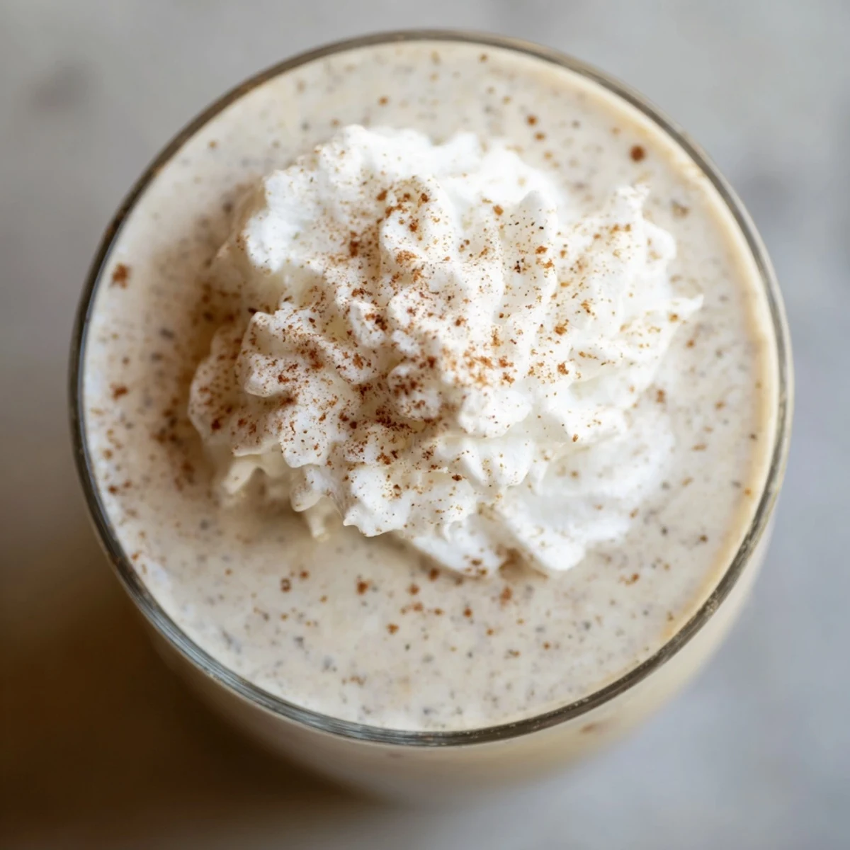 Festive low-carb eggnog beverage garnished with cinnamon and vanilla in a clear glass