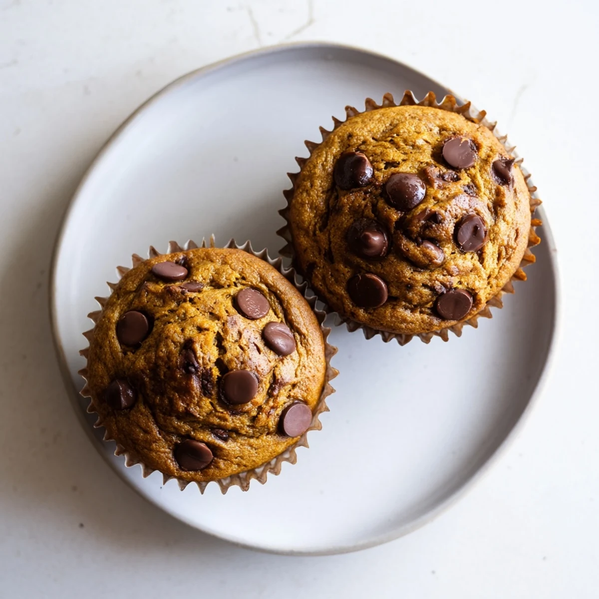 Freshly baked peanut butter banana muffins with moist crumb and chocolate chip bits