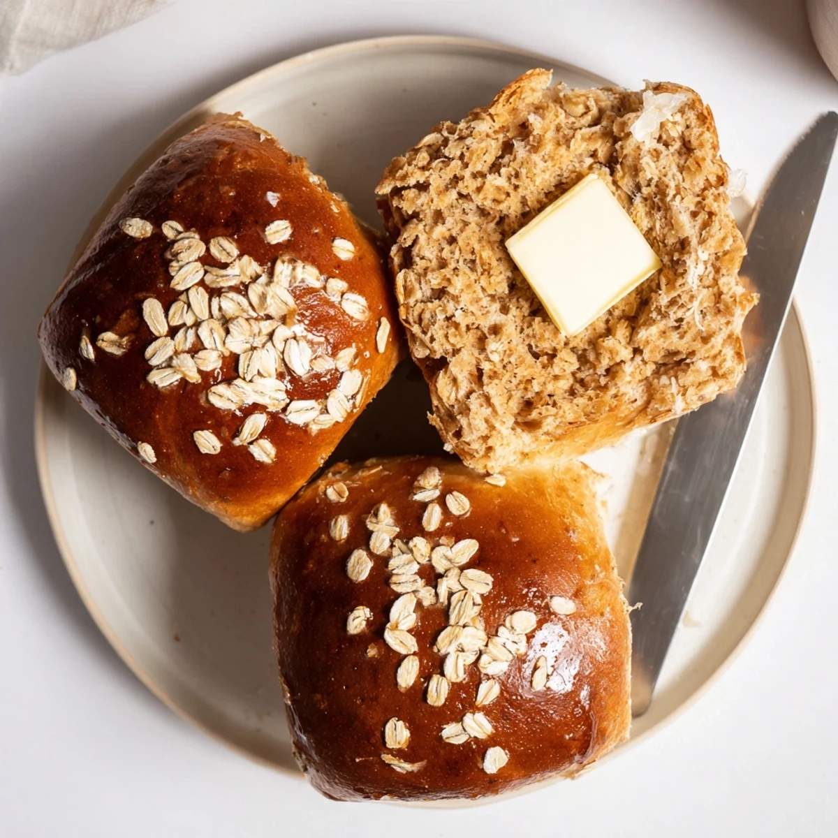 Freshly baked Rustic Oatmeal Molasses Dinner Rolls, warm, earthy molasses aroma.