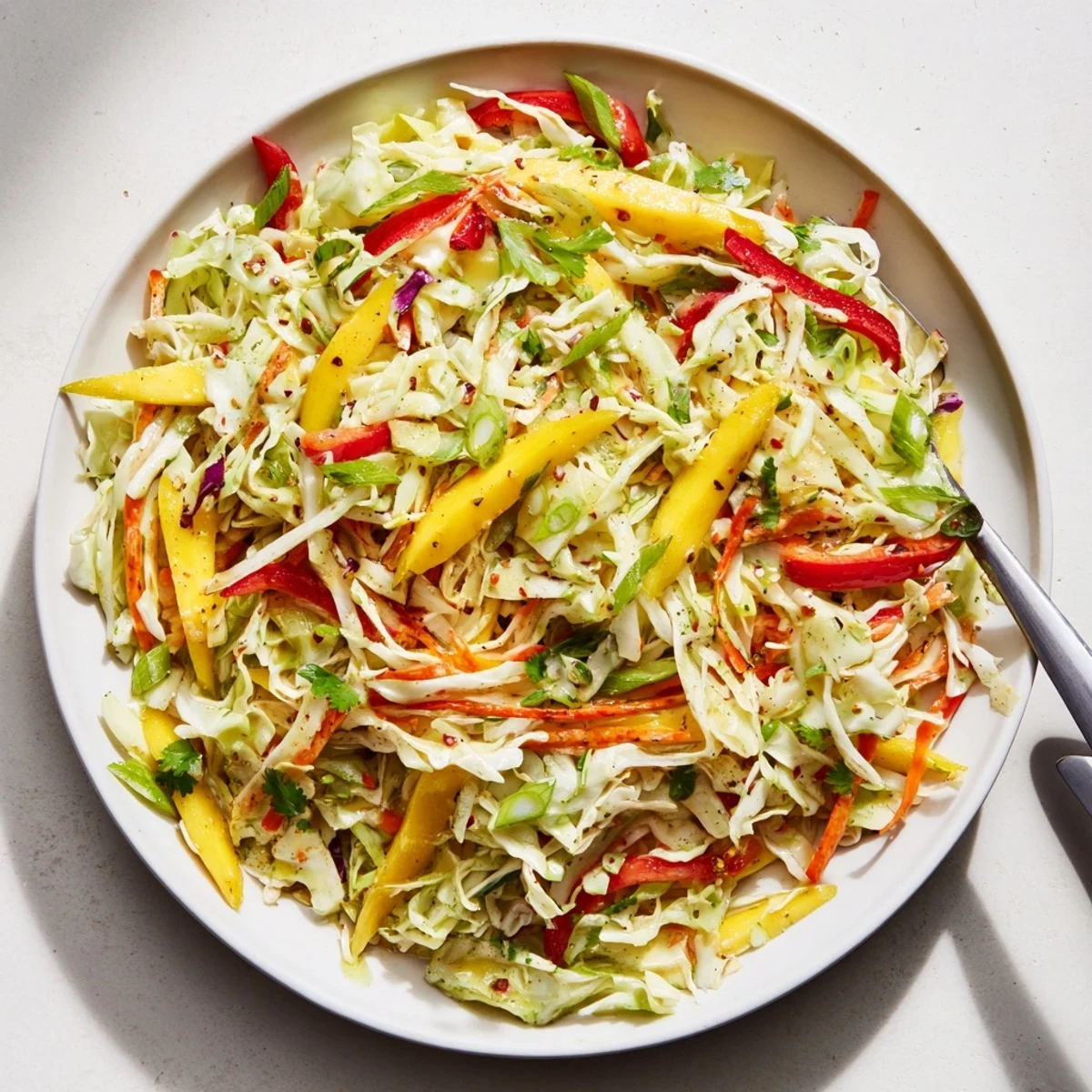 Mango Cabbage Citrus Slaw served beside grilled fish, balancing smoky flavors