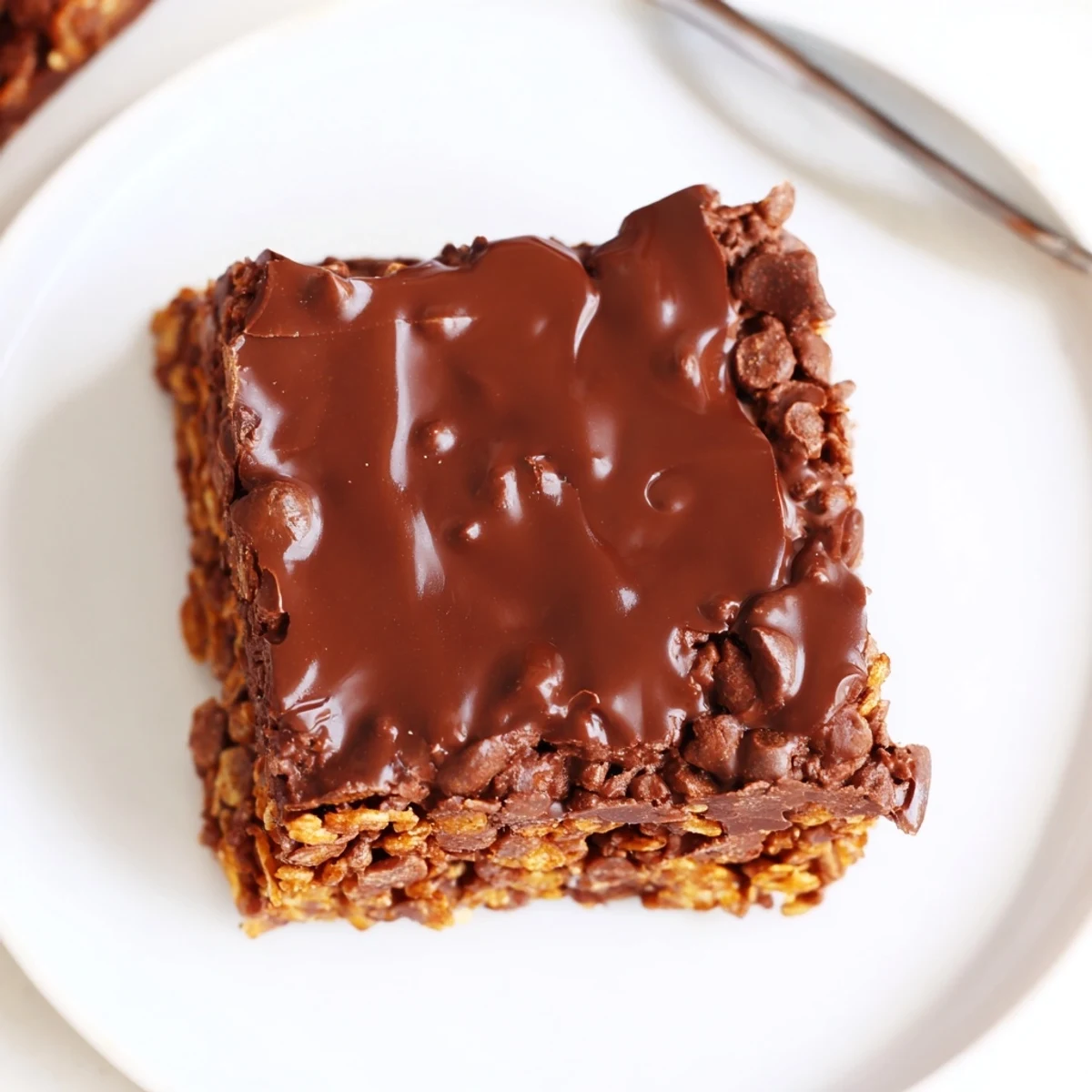 Cornflake Chocolate Fudge Bars arranged on a plate beside steaming coffee