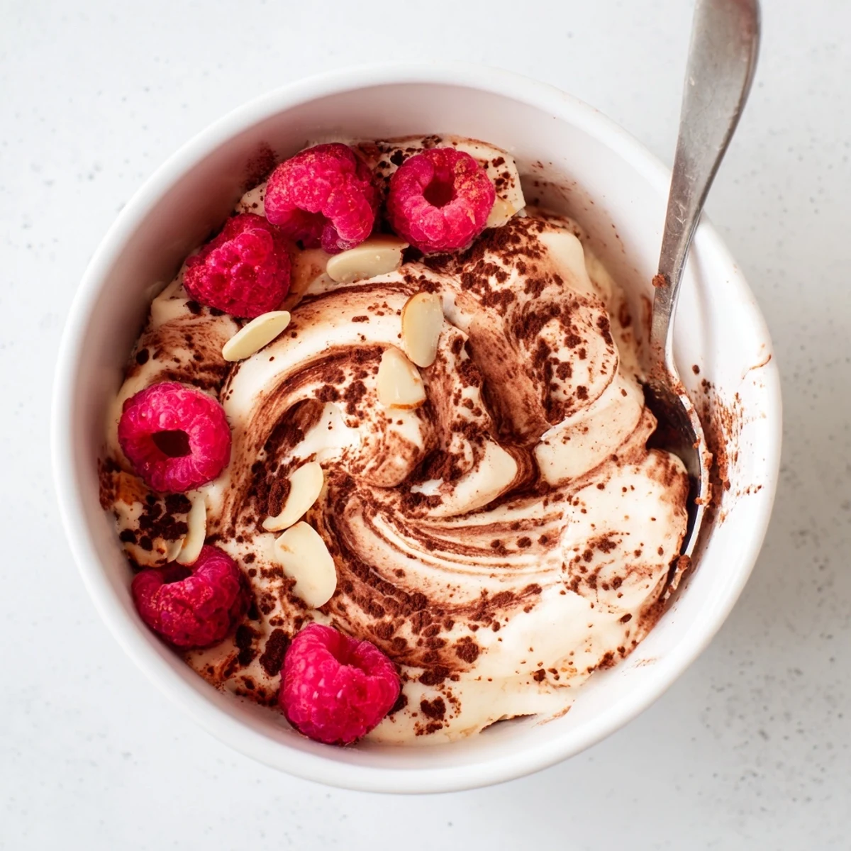 Golden healthy nice cream recipe garnished with coconut flakes and chopped nuts for an indulgent vegan dessert