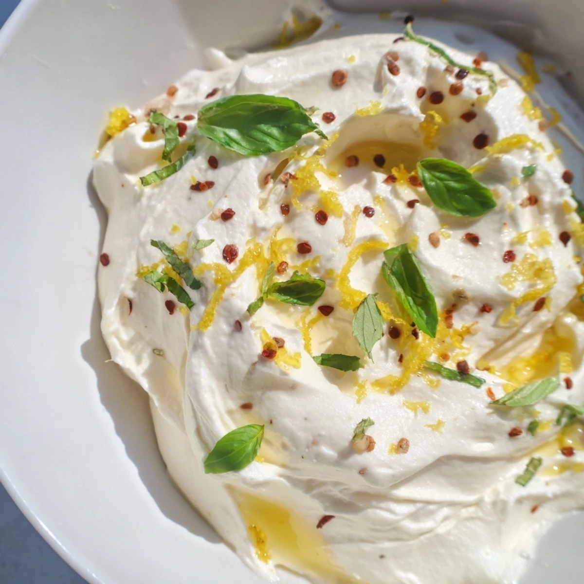 Light and airy whipped ricotta appetizer with cracked pepper and olive oil garnish