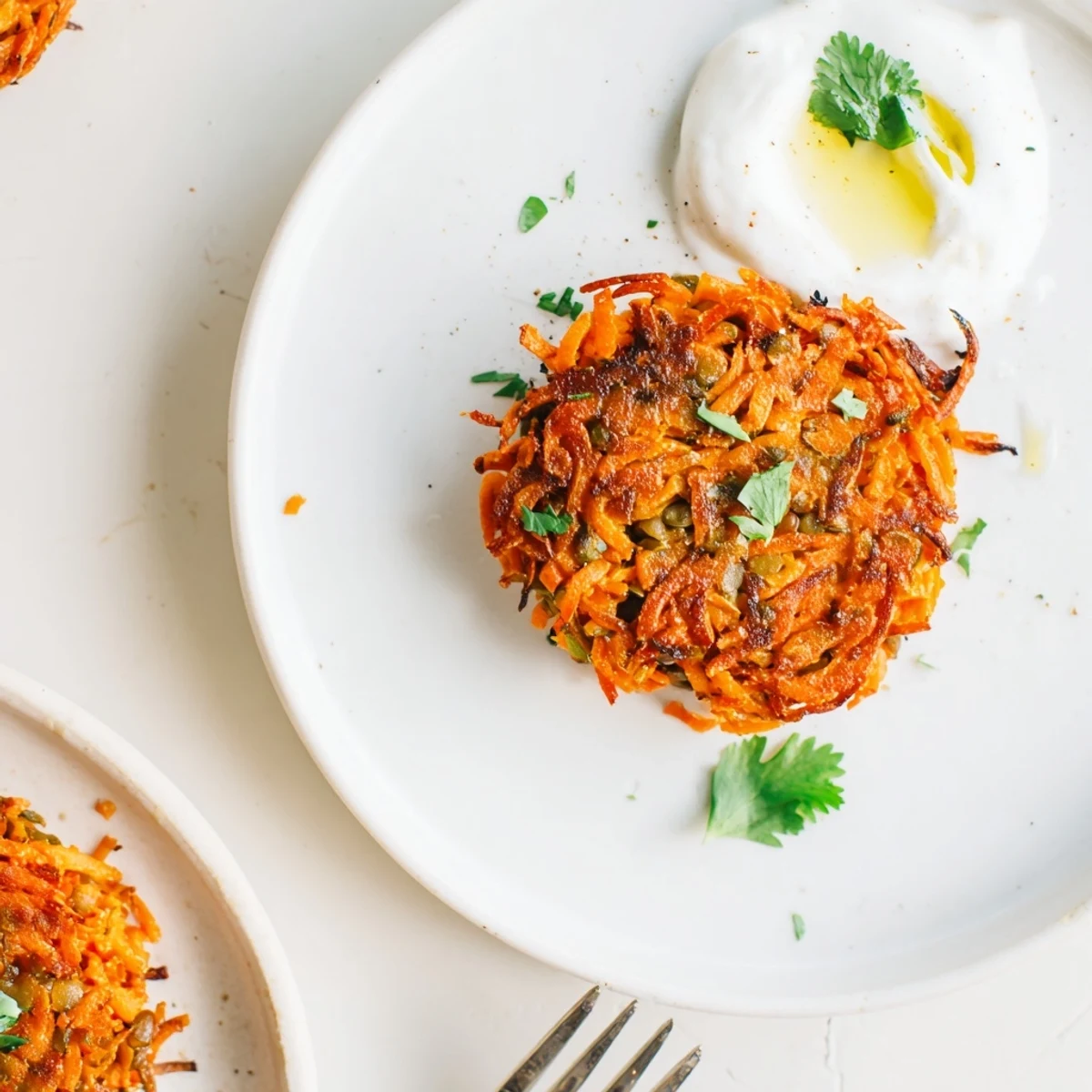 Skillet-seared Crispy Sweet Potato Lentil Patties resting on greens with cilantro