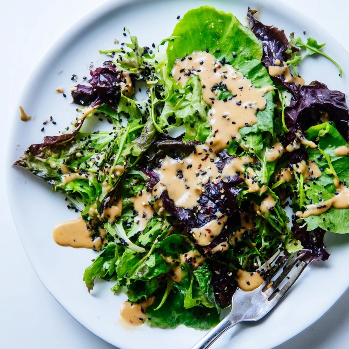 Smooth Asian-inspired dressing with nutty aroma poured from glass jar spoon