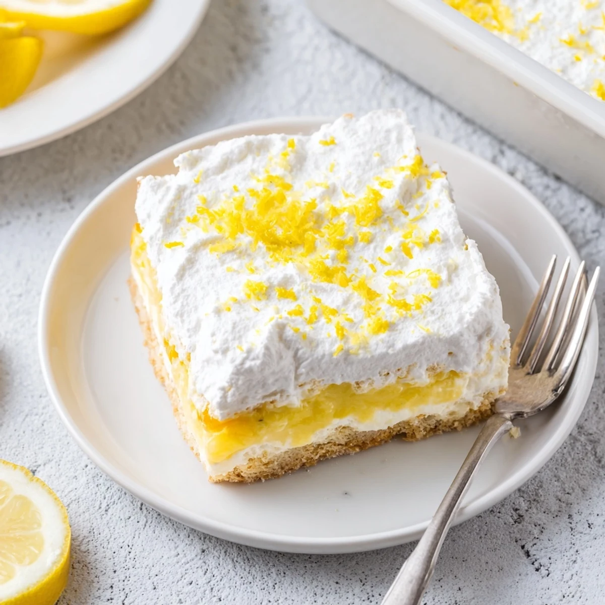 Chilled Lemon Lush Cake dessert with buttery crust, creamy filling, and light citrus garnish