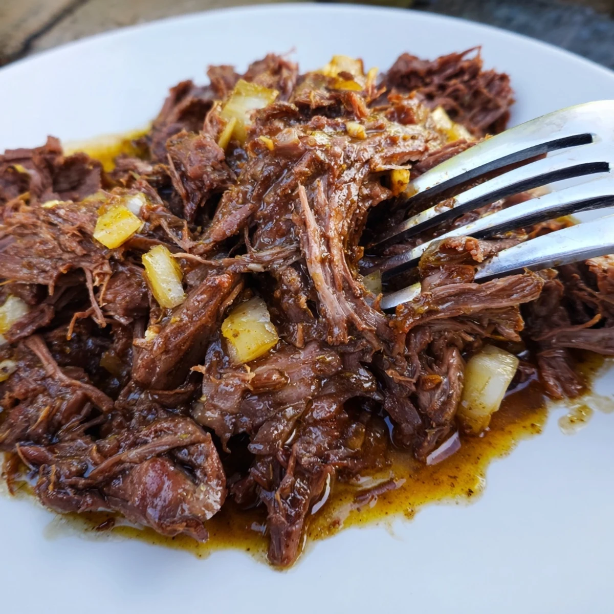 Flavorful Slow Cooker Beef Barbacoa in a bowl surrounded by toppings like avocado and salsa