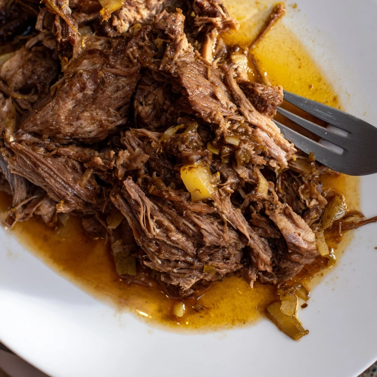 Succulent Mexican-style Slow Cooker Beef Barbacoa piled high with diced onions and lime wedges