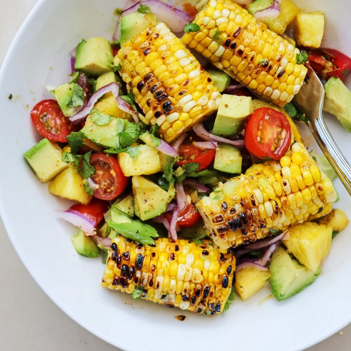 Tropical Charred Corn And Avocado Salad with smoky kernels, creamy texture, cilantro.
