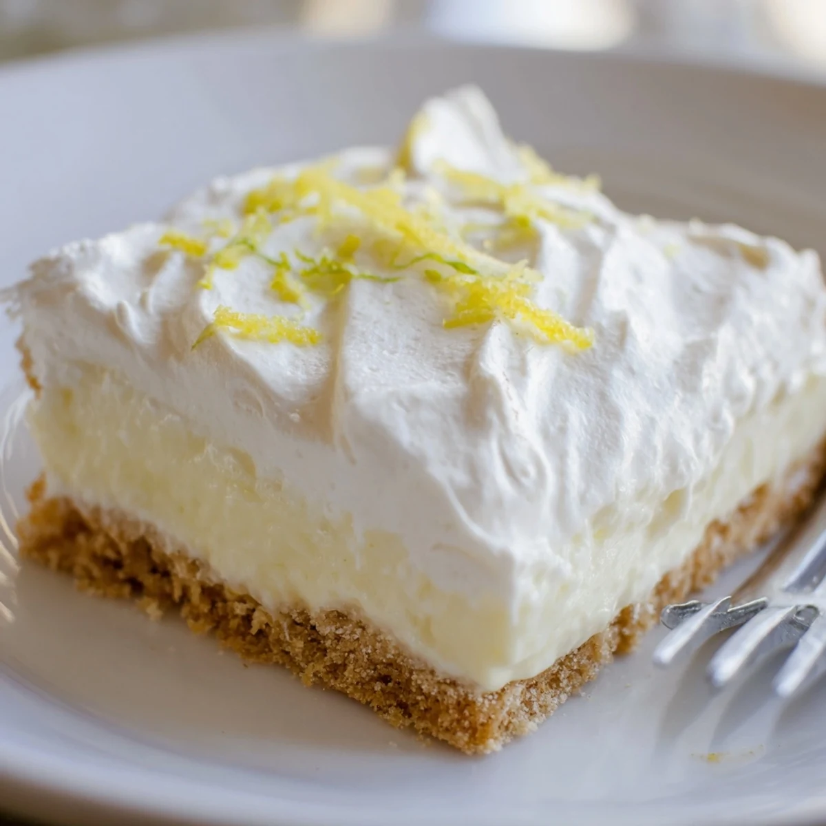 Sliced Lemon Lush Cake on 9x13 pan, buttery cookie crust visible