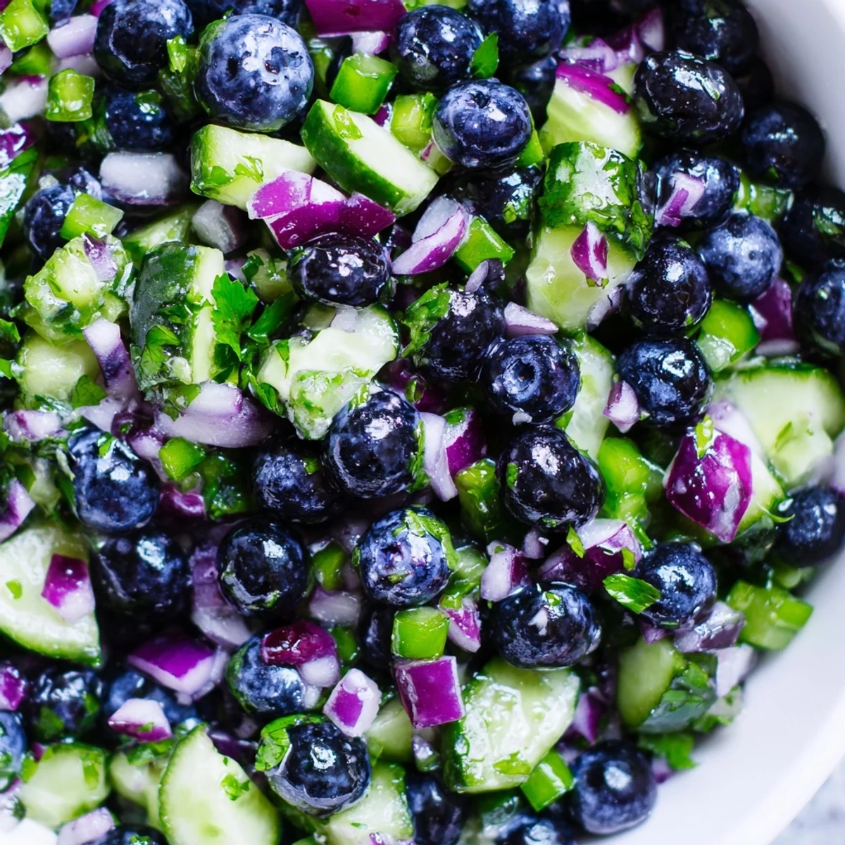 Fresh blueberry cucumber salsa in a bowl with tortilla chips nearby, vibrant and colorful