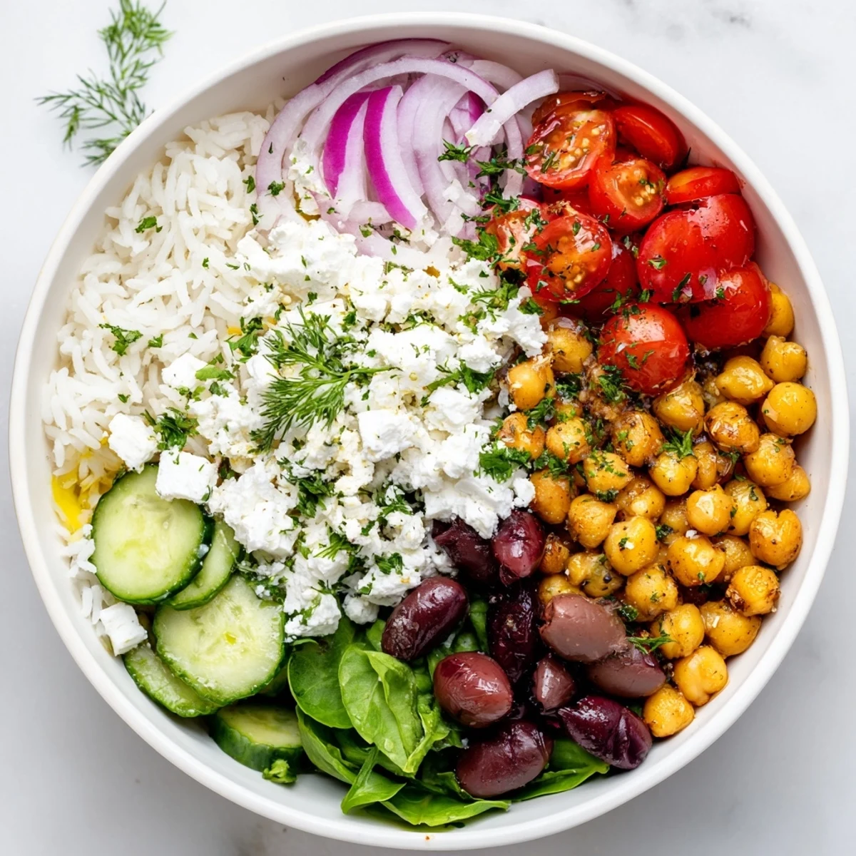 Colorful Mediterranean Rice Bowl topped with crisp vegetables, feta, and fragrant herbs