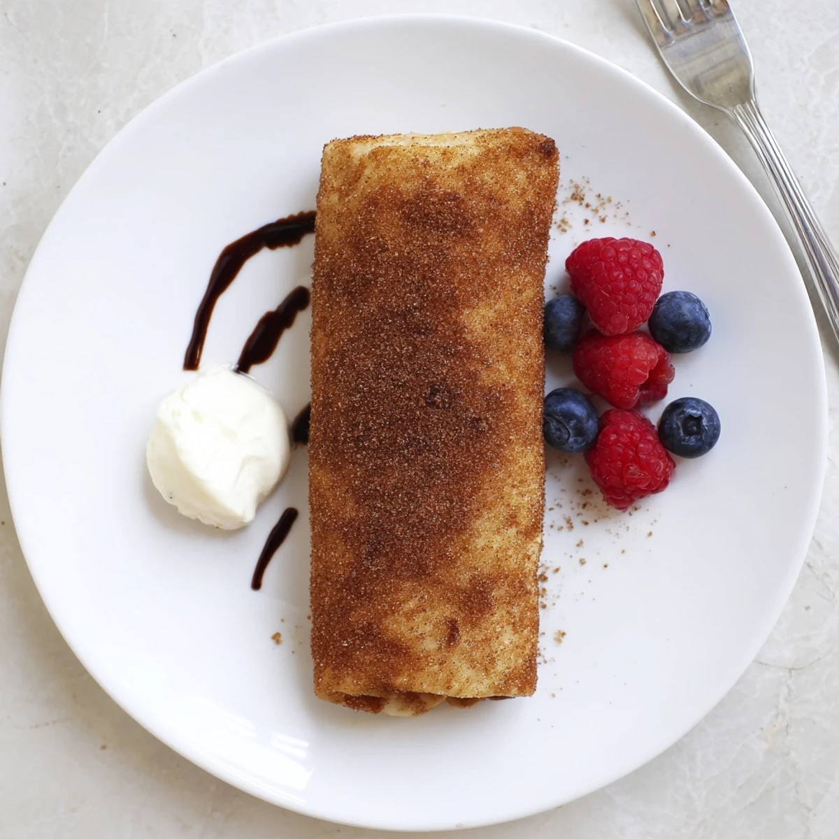 Creamy cheesecake chimichangas with a golden crispy tortilla shell cut open to reveal filling