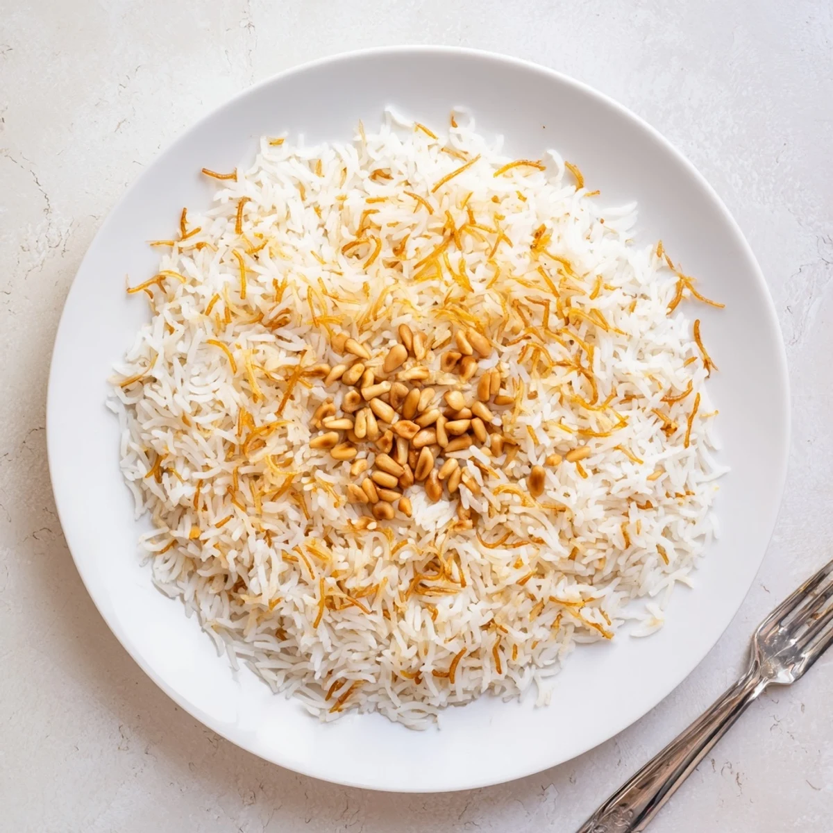 Steaming plate of Lebanese rice alongside grilled meats and roasted Mediterranean vegetables
