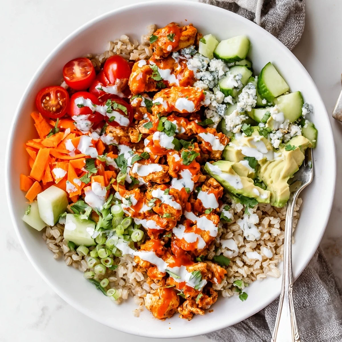 Spicy buffalo chicken served over fluffy grains with fresh avocado and crumbled blue cheese