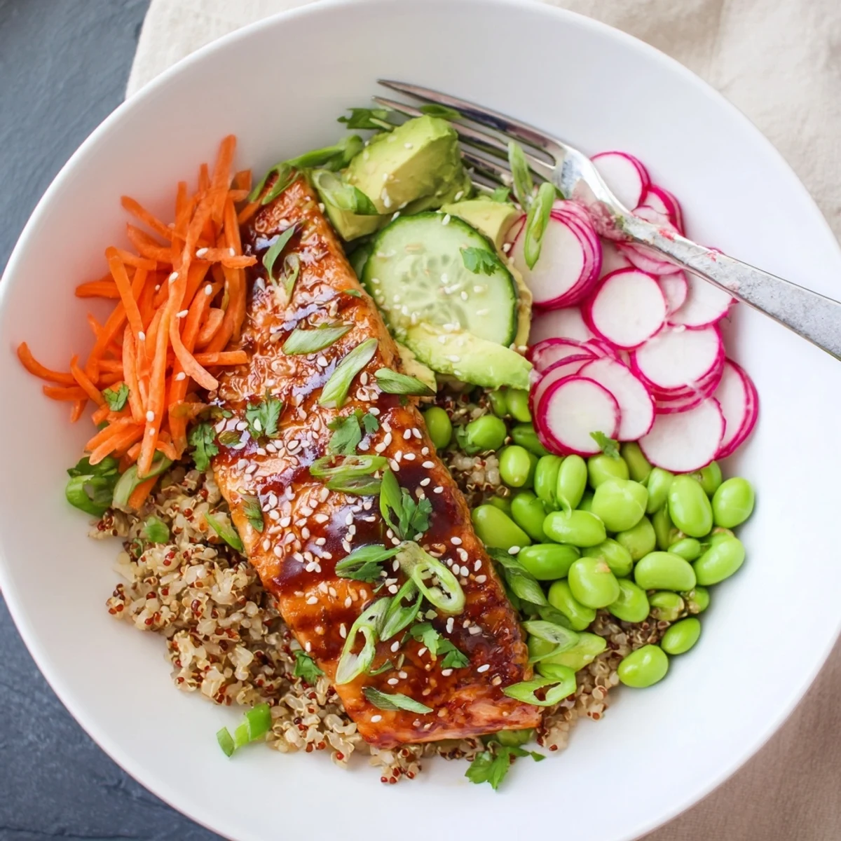 Hearty Asian salmon grain bowl layered with tender glazed fish and fresh avocado
