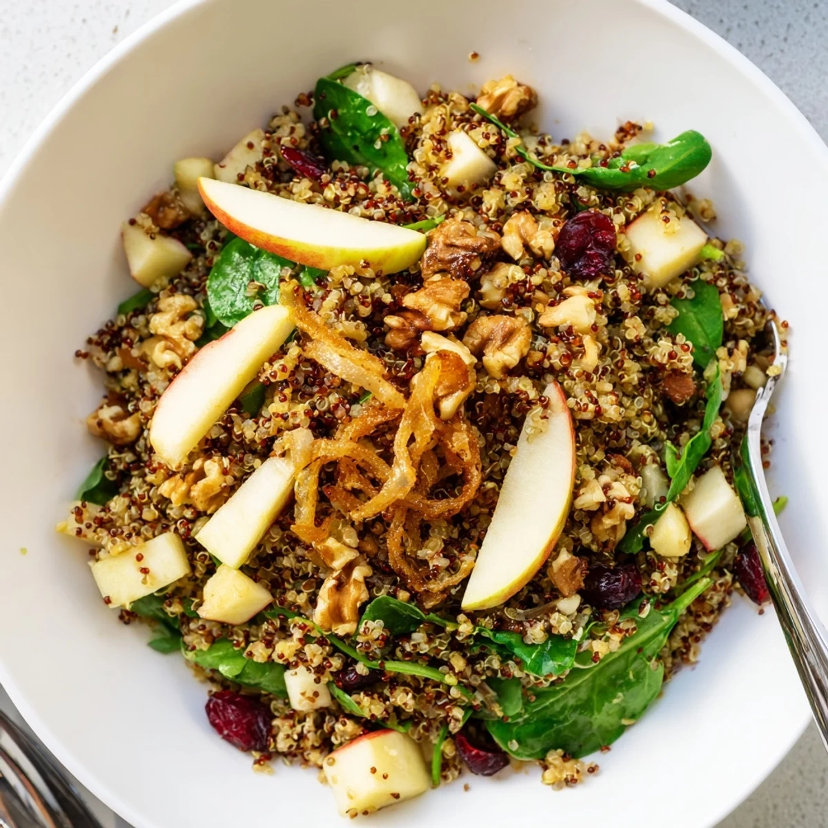 Honey Mustard Quinoa Apple Salad with golden crispy shallots on a rustic wooden bowl
