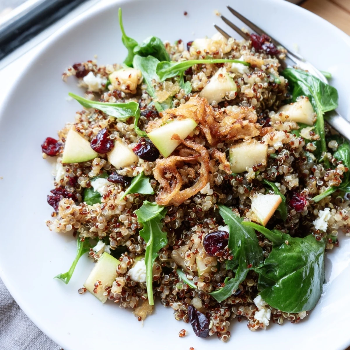 A colorful Honey Mustard Quinoa Apple Salad tossed with cranberries, nuts, and leafy greens