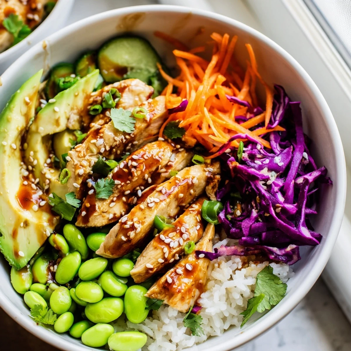 Golden marinated chicken strips nestled over crisp cabbage, carrots, and fluffy white rice