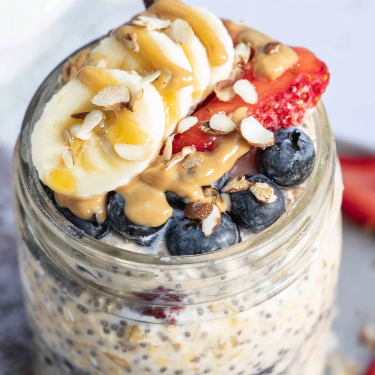 Creamy protein overnight oats topped with fresh berries and a drizzle of nut butter