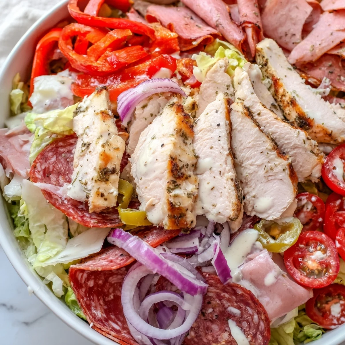 Colorful Italian grinder chicken salad layered with provolone salami and roasted red peppers
