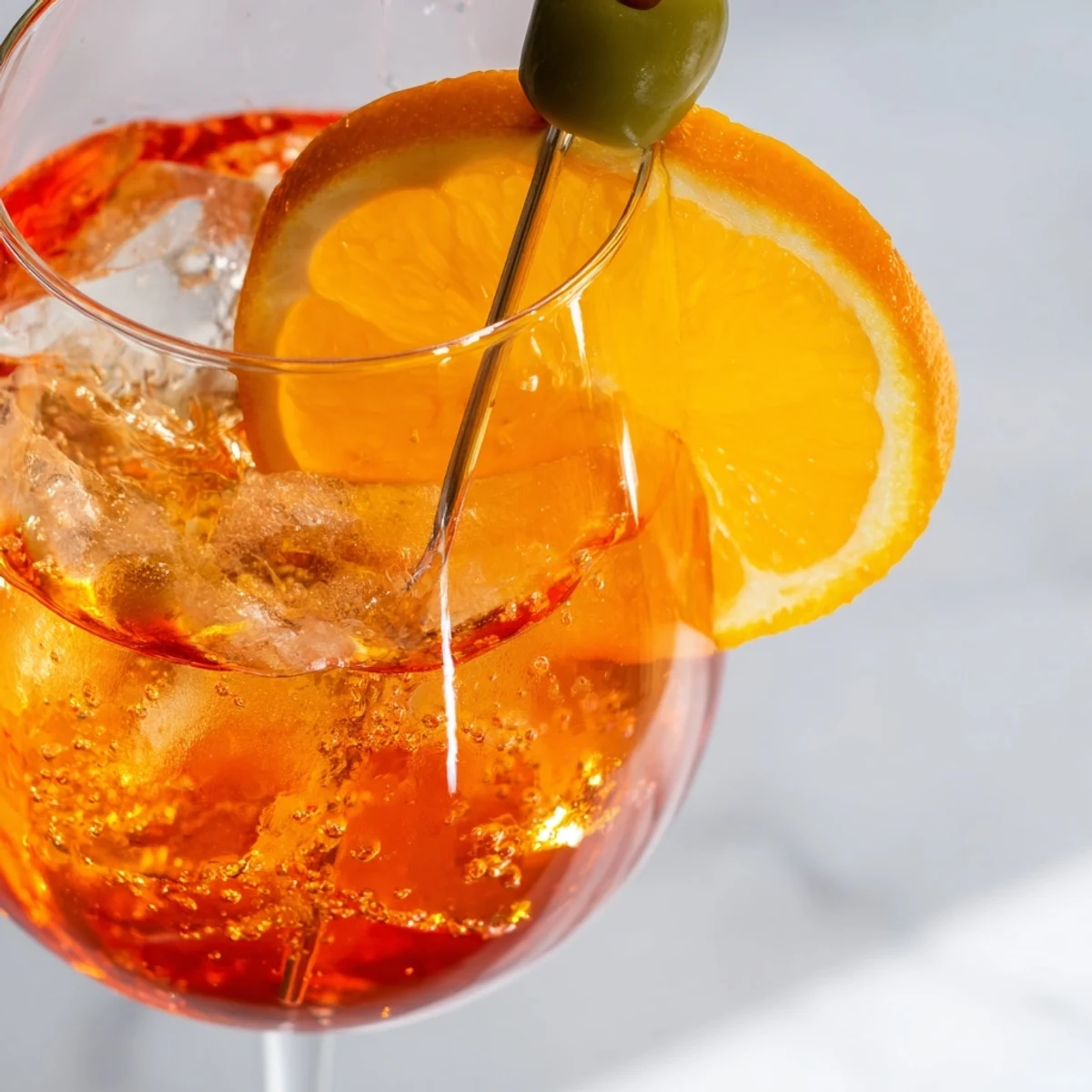 Refreshing Spritz drink topped with soda water and olive garnish.  