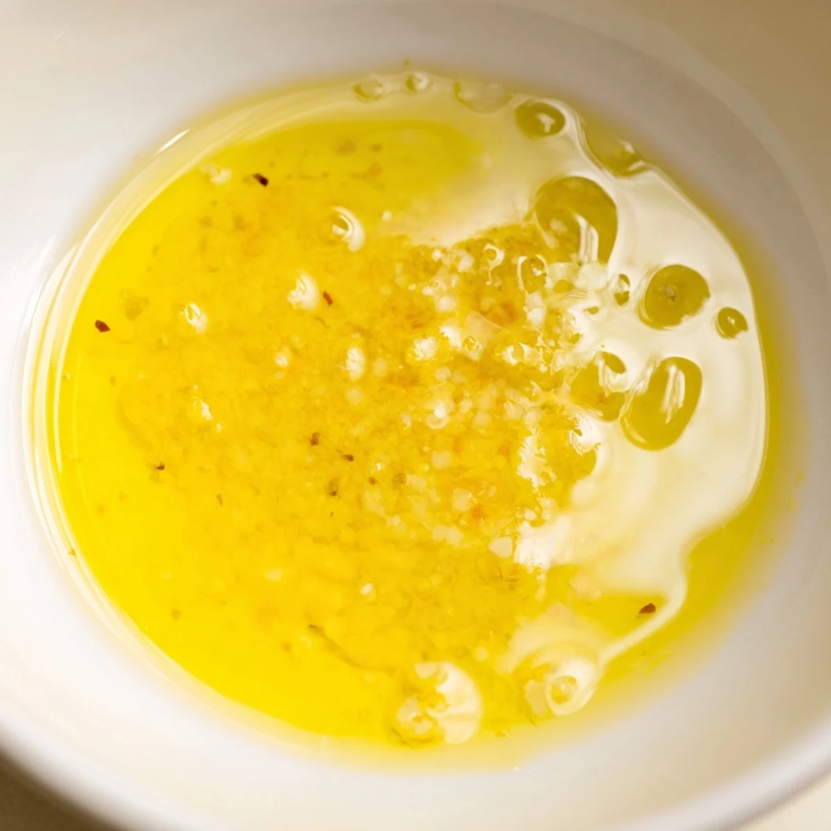 Golden lemon vinaigrette dressing recipe poured over crisp vegetables for a vibrant, tangy marinade.