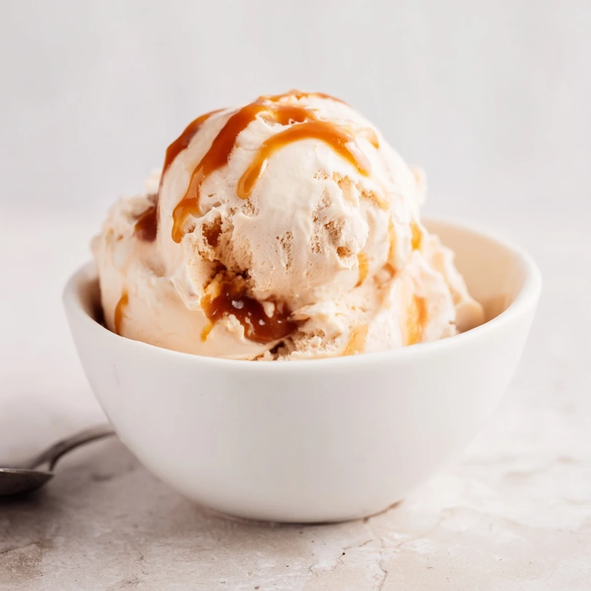 Creamy homemade salted caramel ice cream scooped into a waffle cone for dessert.  