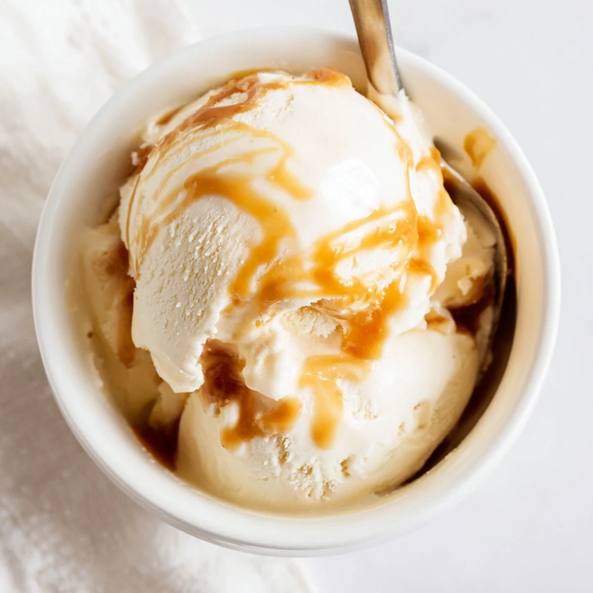 Rich no churn salted caramel ice cream with golden caramel swirls in a bowl.  