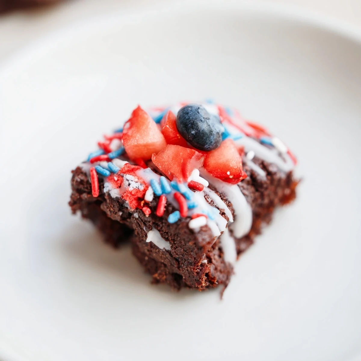 Glazed Fourth of July brownie bites decorated with fresh fruit for patriotic parties.