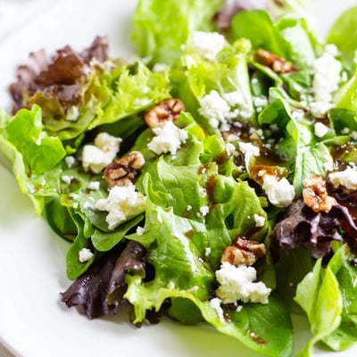 Crisp spring mix salad topped with crumbled feta, toasted pecans, and fresh vegetables.
