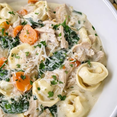 Crockpot Chicken Tortellini with tender shredded meat and vibrant spinach in sauce