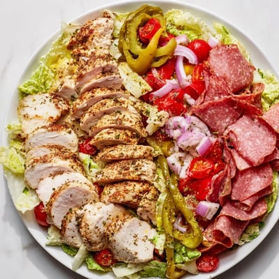 Hearty Italian grinder chicken salad drizzled with zesty dressing over crisp romaine lettuce