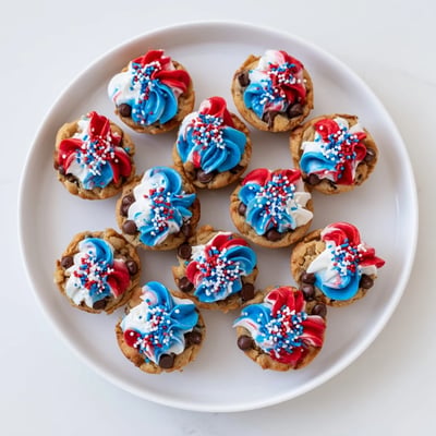Golden baked chocolate chip cookie cups filled with creamy frosting and festive sprinkles  
